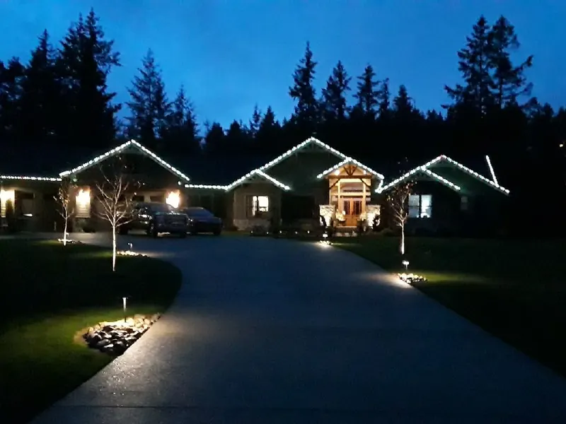 Wide single-storey home with every gable outlined in white lights under a blue dusk sky
